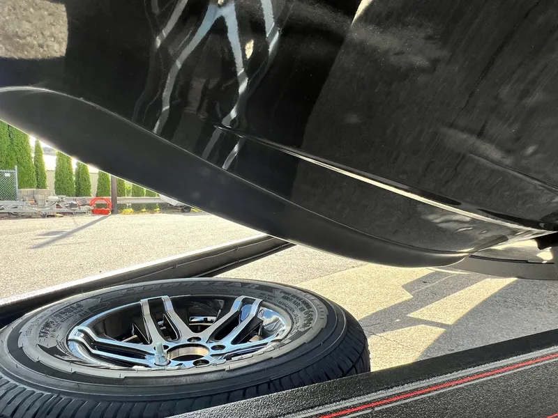 Slide: The Image of Close-up of a 2025 Skeeter ZXR 21 boat hull and trailer wheel. - 14