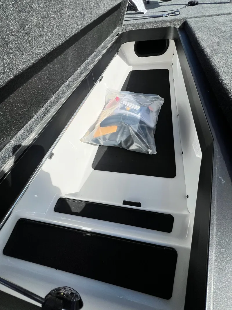 Slide: The Image of 2025 Skeeter ZXR 21 boat storage compartment with packaged accessories. - 26