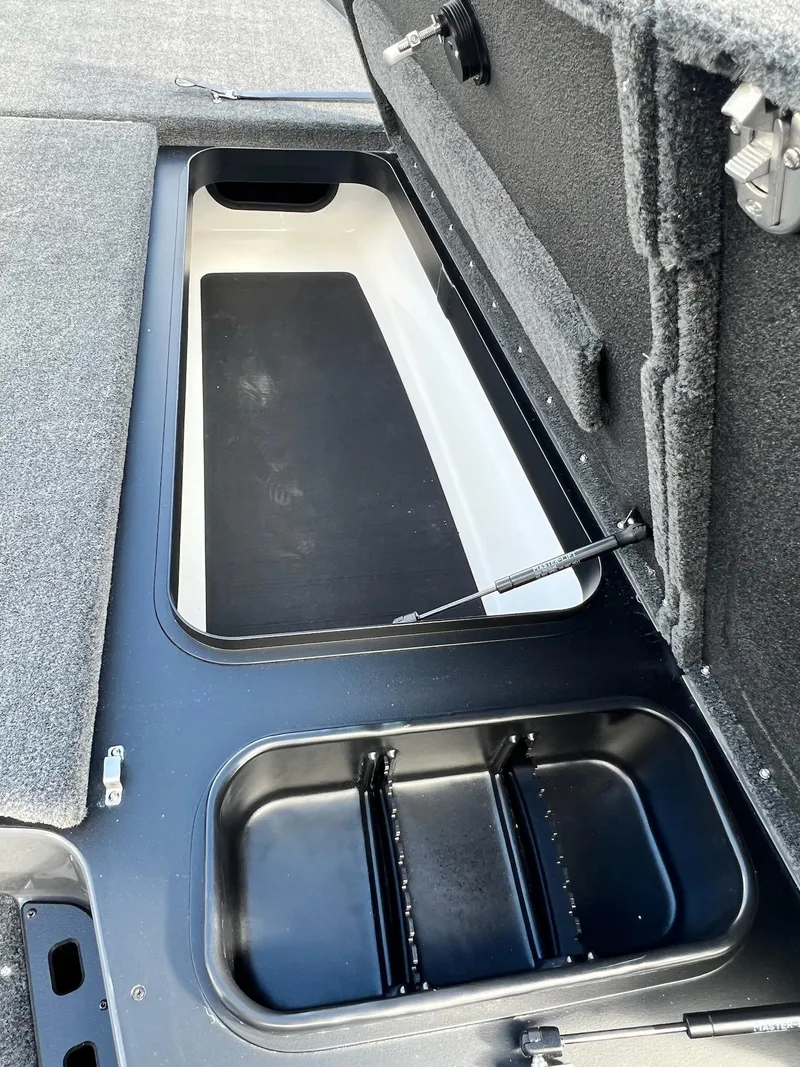 Slide: The Image of 2025 Skeeter ZXR 21 boat storage compartments with open lids, showcasing interior design. - 37