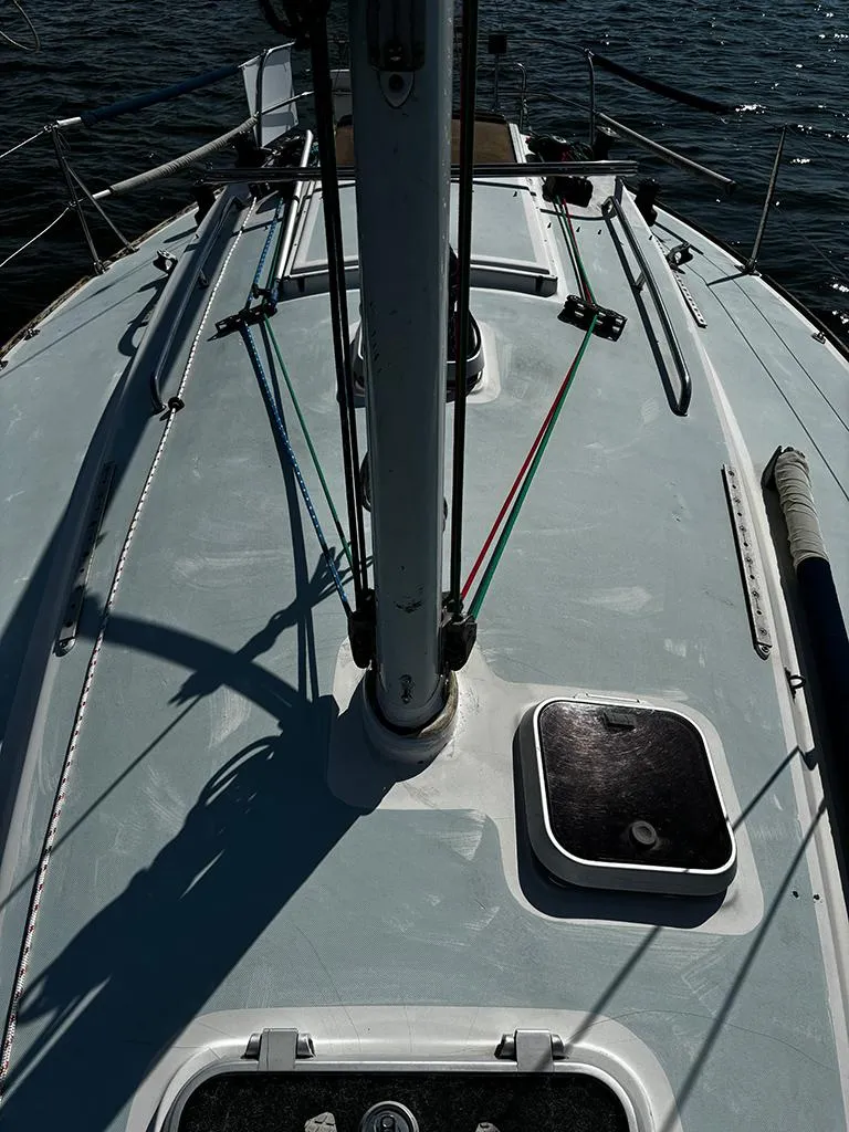 Slide: The Image of 1982 J Boats 30 sailboat deck with mast and rigging, on calm water. - 6