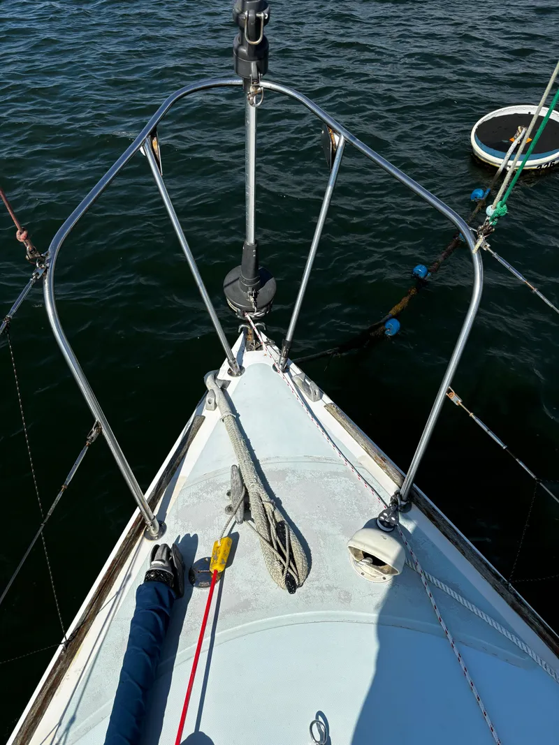 Slide: The Image of Bow of 1982 J Boats 30 sailboat with ropes and anchor, on calm water. - 7