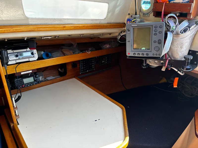 Slide: The Image of Navigation station inside a 1982 J Boats 30, featuring electronic equipment and storage. - 8