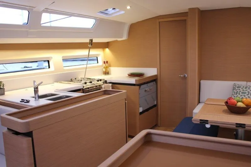 Slide: The Image of Interior of 2024 Jeanneau Sun Odyssey 490 yacht, featuring modern kitchen and dining area. - 43