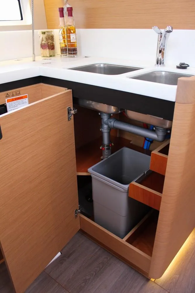 Slide: The Image of 2025 Jeanneau Sun Odyssey 440 kitchen sink area with open cabinet storage. - 16