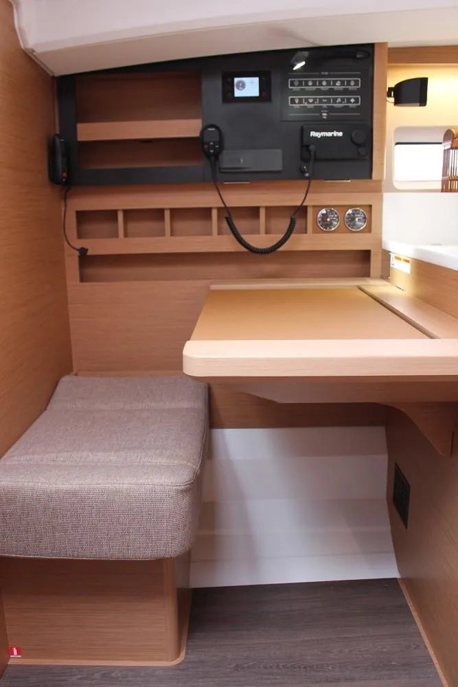 Slide: The Image of 2025 Jeanneau Sun Odyssey 440 interior navigation station with control panel and seating. - 5