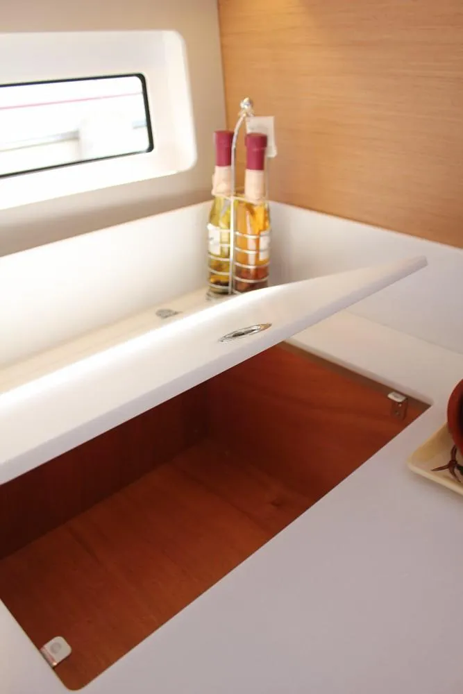 Slide: The Image of 2024 Jeanneau Sun Odyssey 490 interior with open storage compartment and window. - 11