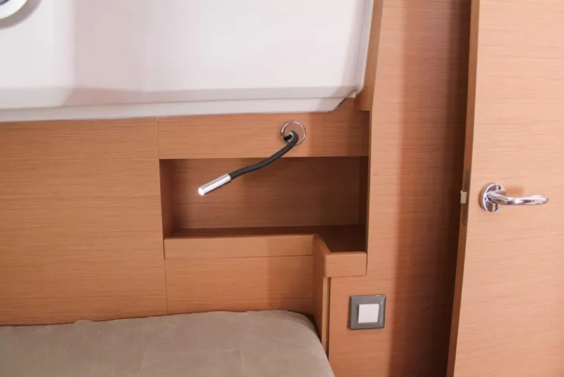 Slide: The Image of Interior of 2024 Jeanneau Sun Odyssey 490 yacht with modern reading light and wooden finish. - 14