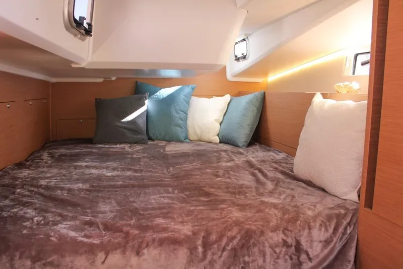 Slide: The Image of Cozy cabin interior of 2024 Jeanneau Sun Odyssey 490 with plush bedding and cushions. - 15