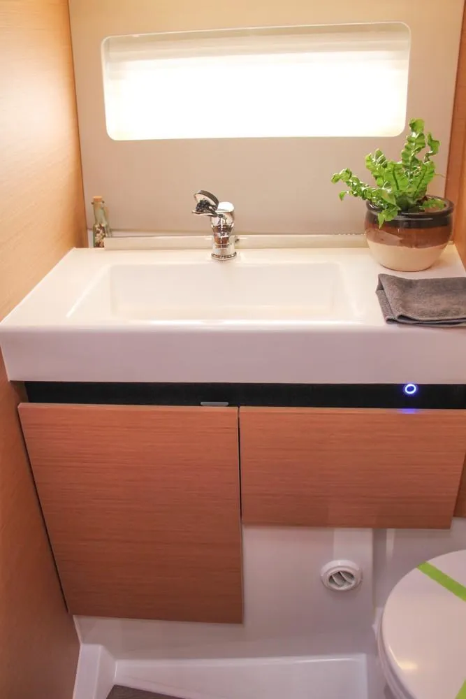 Slide: The Image of Modern bathroom in 2024 Jeanneau Sun Odyssey 490 yacht with sink and potted plant. - 21
