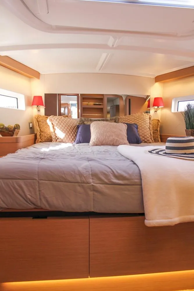 Slide: The Image of Luxurious cabin interior of 2024 Jeanneau Sun Odyssey 490 yacht, featuring cozy bedding and ambient lighting. - 22