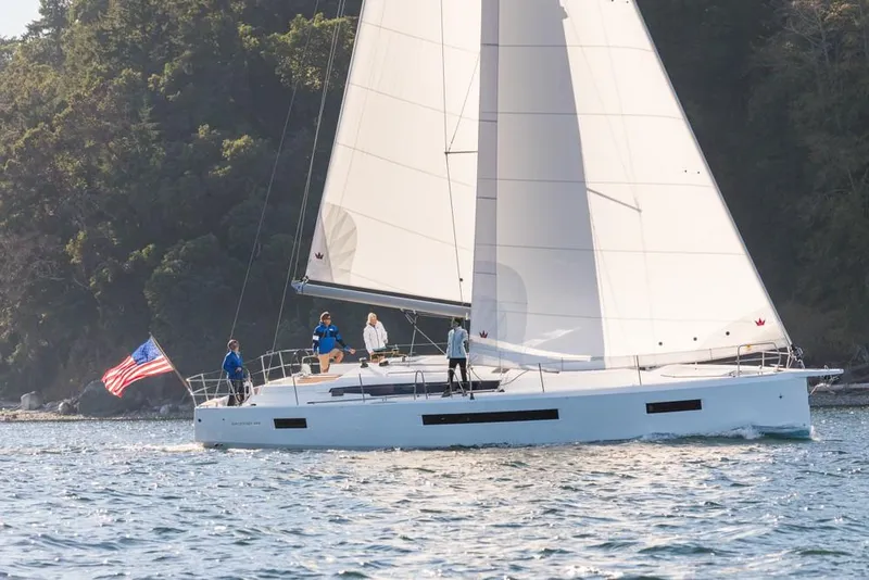 Slide: The Image of 2024 Jeanneau Sun Odyssey 490 sailing near forested coastline. - 48