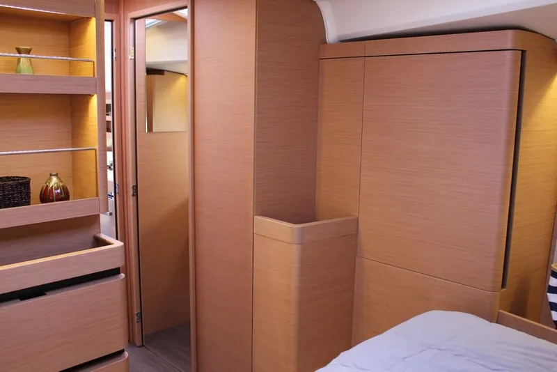 Slide: The Image of Interior of 2024 Jeanneau Sun Odyssey 490 yacht, featuring modern wood cabinetry and shelving. - 5