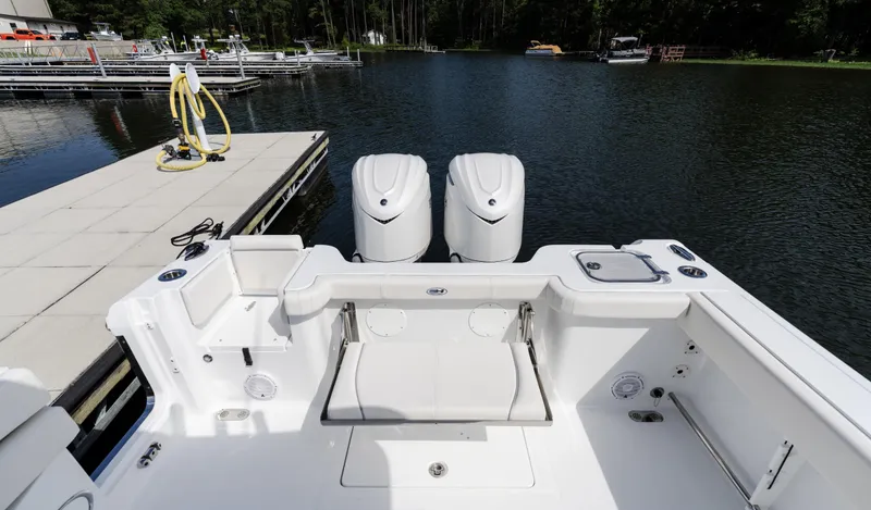 Slide: The Image of 2025 Sea Hunt Gamefish 30 boat with twin engines docked on a serene lake. - 15