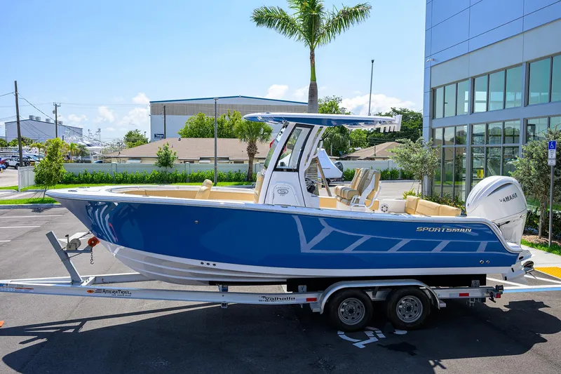 Slide: The Image of 2025 Sportsman Heritage 231 Center Console boat on trailer, parked outdoors. - 0