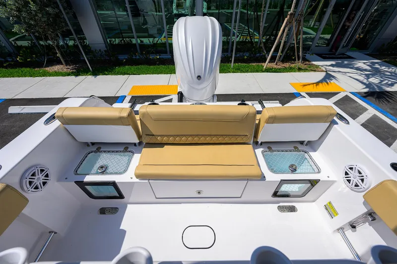 Slide: The Image of 2025 Sportsman Heritage 231 Center Console boat interior with tan seating and storage compartments. - 14