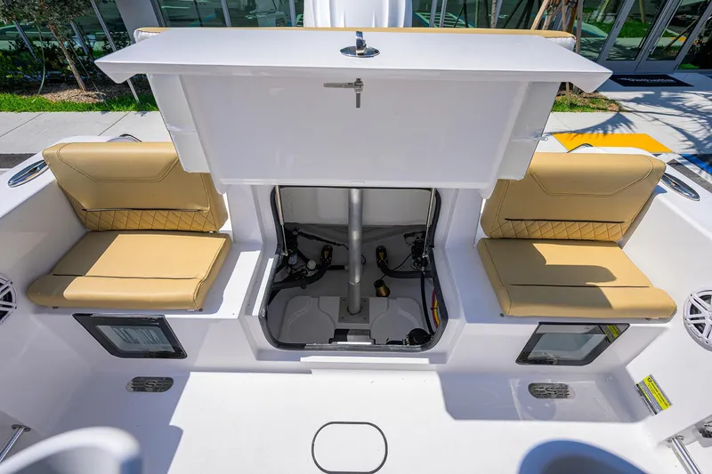 Slide: The Image of 2025 Sportsman Heritage 231 Center Console boat interior with tan seating and storage compartments. - 17