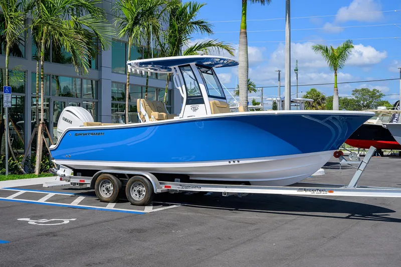 Slide: The Image of 2025 Sportsman Heritage 231 Center Console boat on trailer, parked near palm trees. - 2