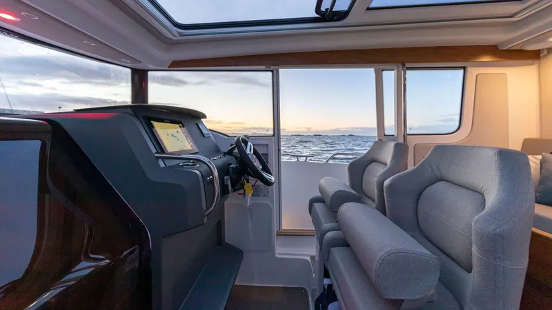 Slide: The Image of Interior of 2024 Nimbus C9 boat with modern dashboard and ocean view. - 12