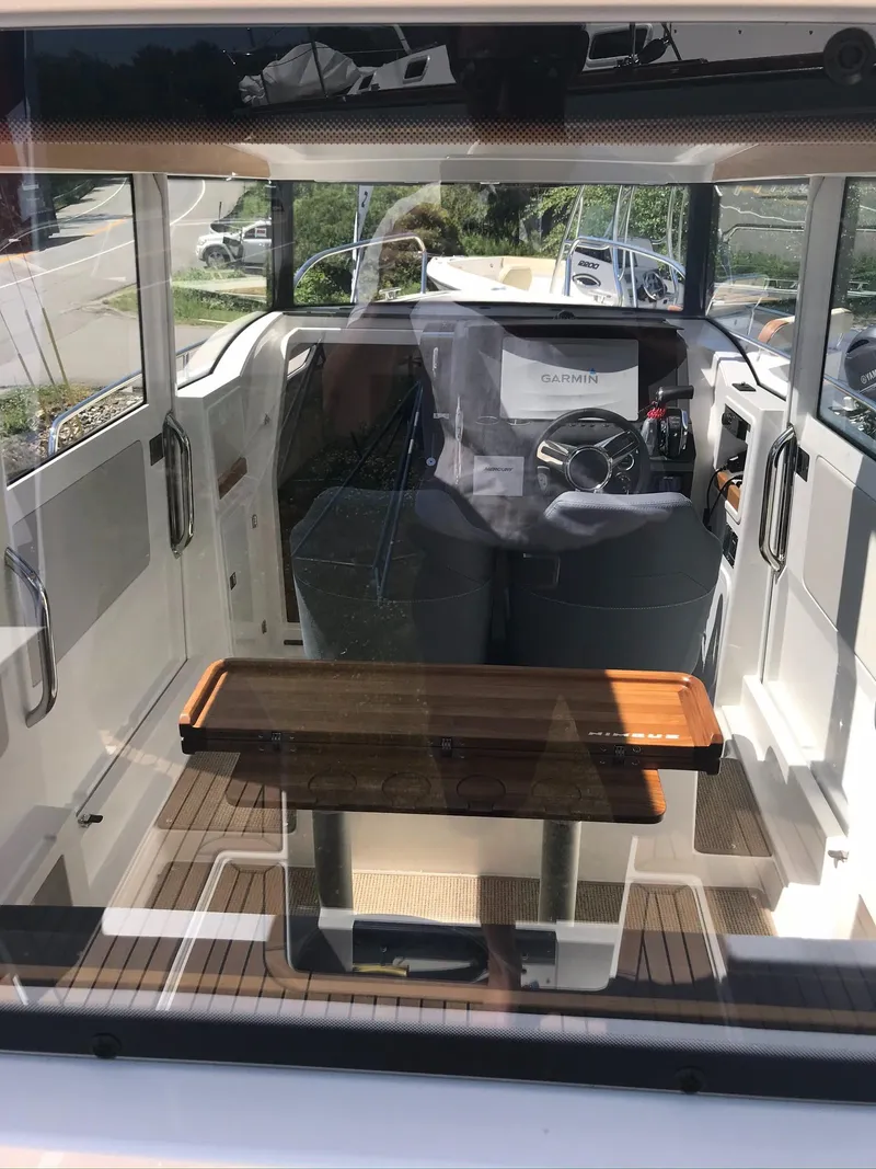 Slide: The Image of Interior view of 2024 Nimbus C9 boat with modern steering and wooden table. - 19