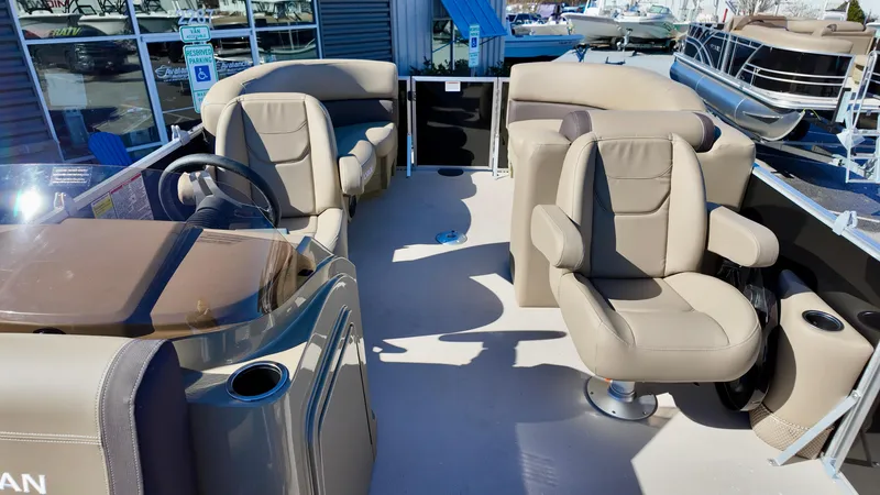 Slide: The Image of 2025 Sylvan Mirage 820 LZ pontoon boat interior with beige seating and steering console. - 14