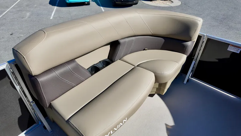 Slide: The Image of 2025 Sylvan Mirage 820 LZ boat seating, beige and brown upholstery, outdoor setting. - 4