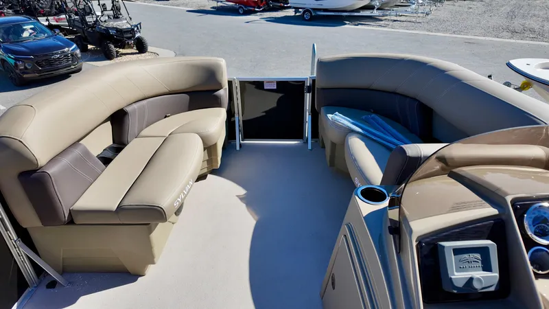 Slide: The Image of 2025 Sylvan Mirage 820 LZ pontoon boat interior with beige seating and helm. - 5