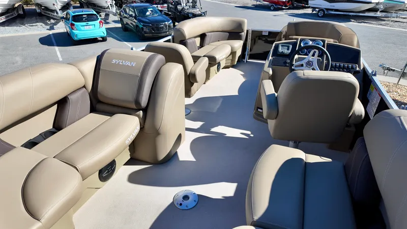 Slide: The Image of 2025 Sylvan Mirage 820 LZ pontoon boat interior with beige seating and steering console. - 6