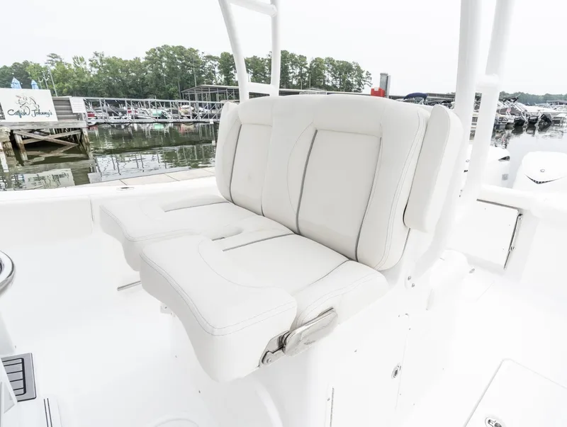 Slide: The Image of 2025 Sea Hunt Gamefish 30 Forward Seating, white cushioned seats, marina background. - 13
