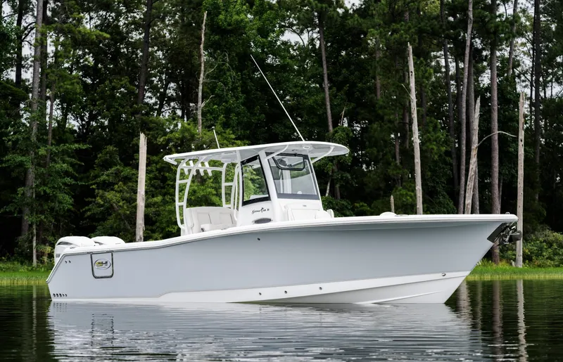 Slide: The Image of 2025 Sea Hunt Gamefish 30 boat on calm water, surrounded by lush trees. - 3