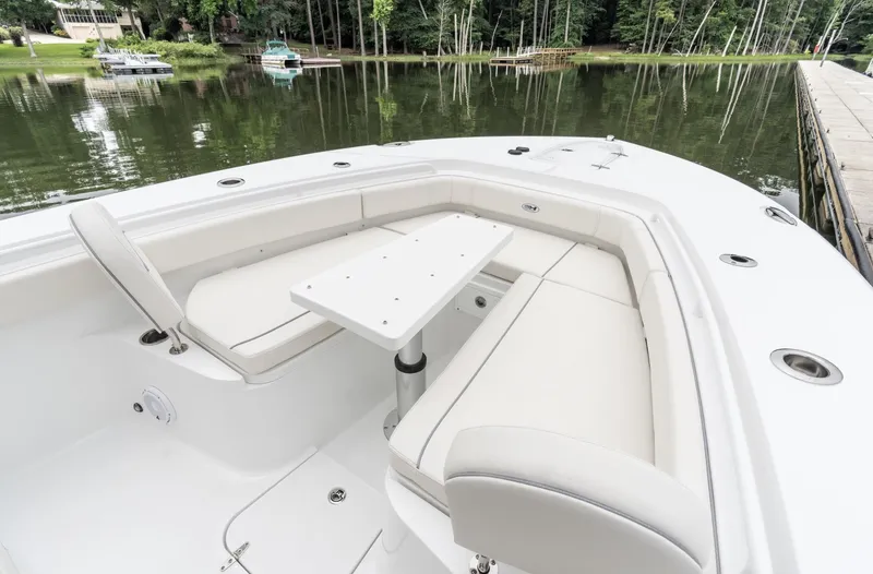 Slide: The Image of 2025 Sea Hunt Gamefish 30 Forward Seating with table, docked by a serene lake. - 7