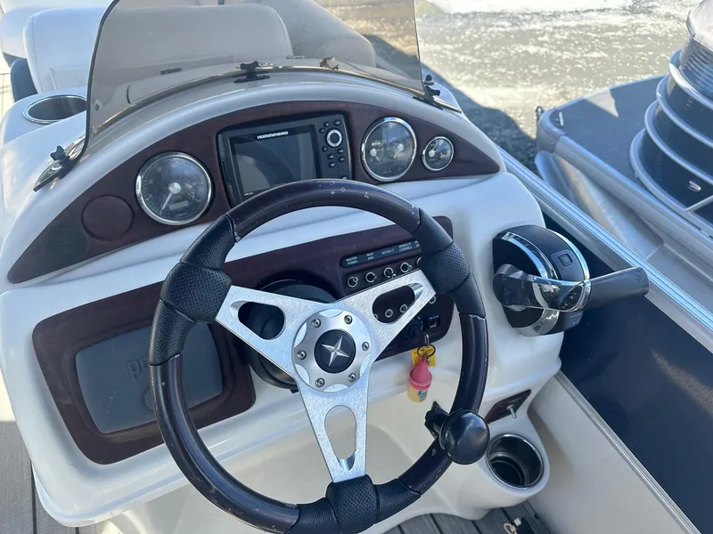 Slide: The Image of 2017 Berkshire 23SLX STS Entertainment boat dashboard with steering wheel and controls. - 4