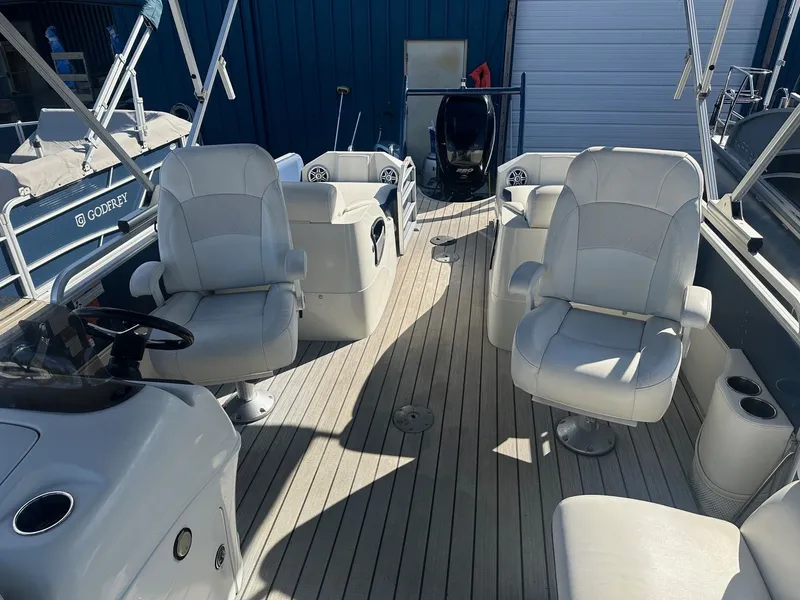 Slide: The Image of 2017 Berkshire 23SLX STS Entertainment boat interior with white seating and wood flooring. - 5