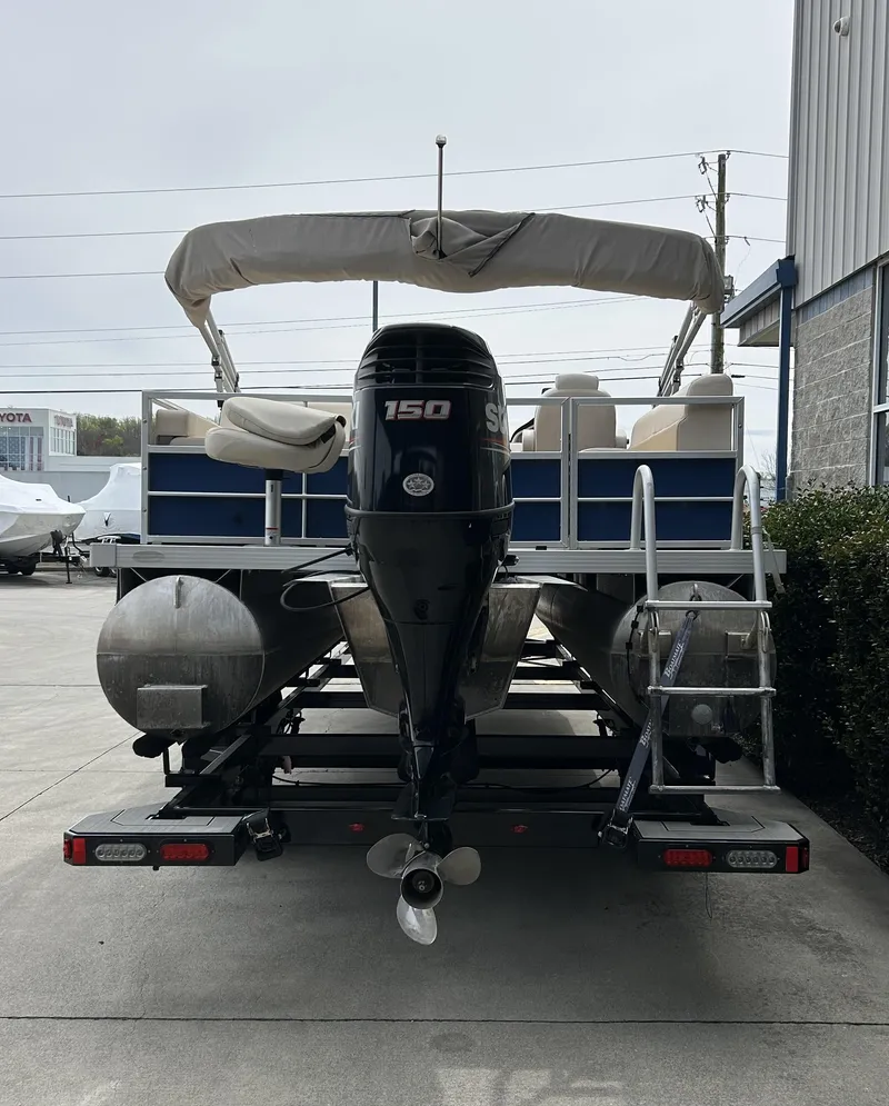 Slide: The Image of 2018 Lexington 325 Sport Tri-Toon boat with outboard motor, parked on trailer. - 4