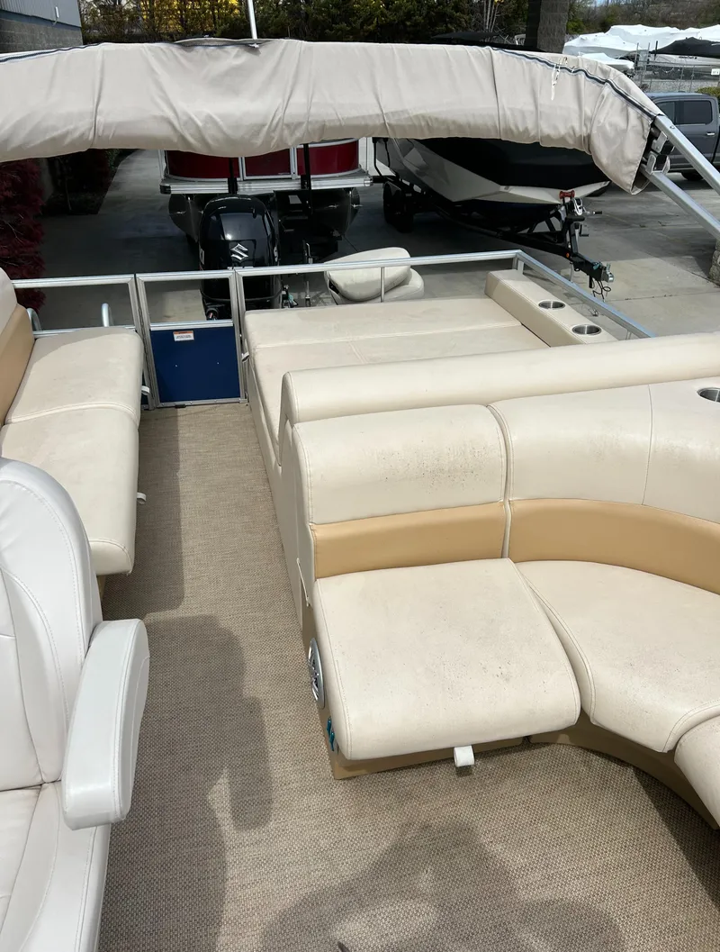Slide: The Image of 2018 Lexington 325 Sport Tri-Toon boat interior with beige seating and carpet. - 5