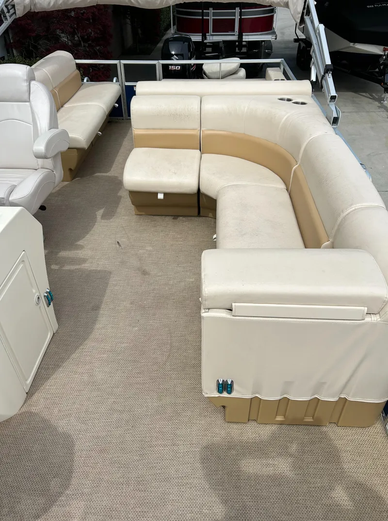 Slide: The Image of 2018 Lexington 325 Sport Tri-Toon boat interior with beige seating and spacious layout. - 6