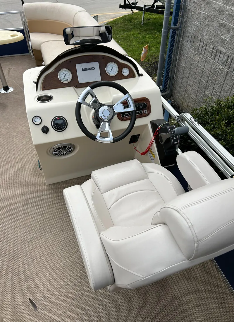 Slide: The Image of 2018 Lexington 325 Sport Tri-Toon boat interior with steering wheel and dashboard. - 8