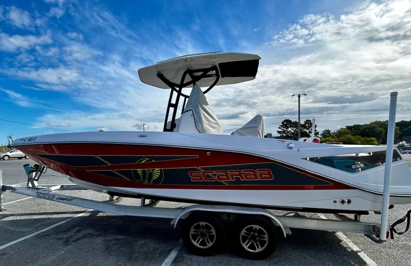 Slide: The Image of 2019 Scarab 255 Open ID boat on trailer under a blue sky. - 4