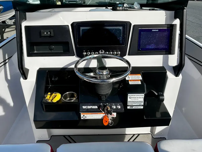 Slide: The Image of 2019 Scarab 255 Open ID boat dashboard with steering wheel and navigation controls. - 6
