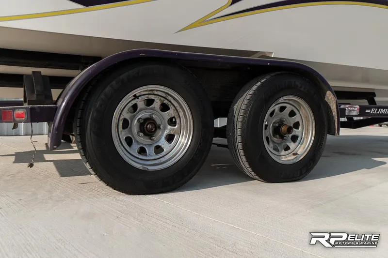 Slide: The Image of Trailer wheels of a 2000 Eliminator 220 Eagle XP boat on concrete surface. - 11