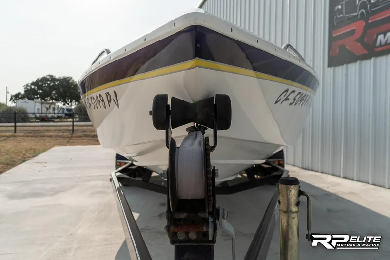 Slide: The Image of 2000 Eliminator 220 Eagle XP boat on trailer, parked outside metal building. - 15
