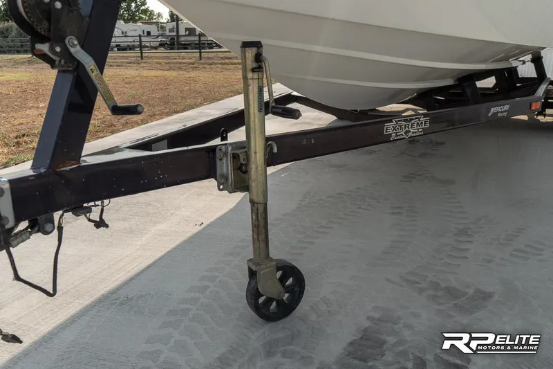 Slide: The Image of 2000 Eliminator 220 Eagle XP boat trailer with wheel jack on concrete surface. - 16