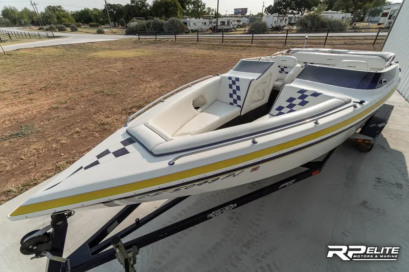 Slide: The Image of 2000 Eliminator 220 Eagle XP speedboat on trailer, white with blue and yellow accents. - 19