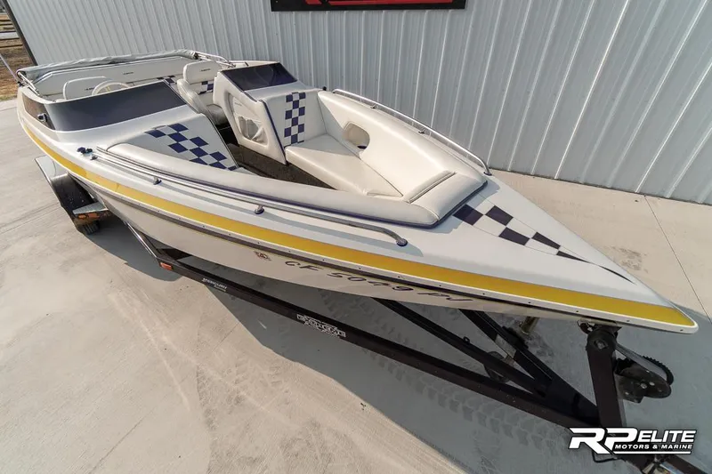 Slide: The Image of 2000 Eliminator 220 Eagle XP speedboat with checkered design on trailer. - 22