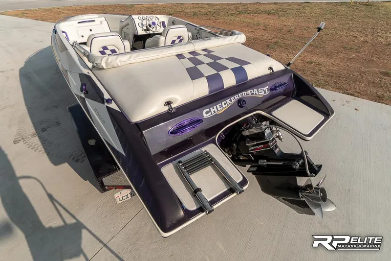 Slide: The Image of 2000 Eliminator 220 Eagle XP speedboat with checkered design and powerful engine. - 32