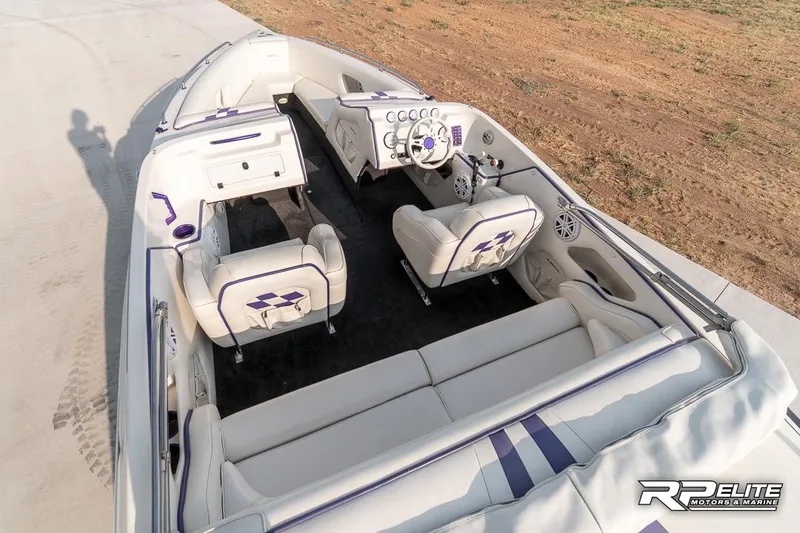 Slide: The Image of 2000 Eliminator 220 Eagle XP boat interior with white and purple seating, steering console, and open layout. - 40