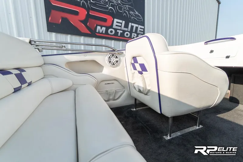 Slide: The Image of Interior of 2000 Eliminator 220 Eagle XP boat with white seating and purple accents. - 46