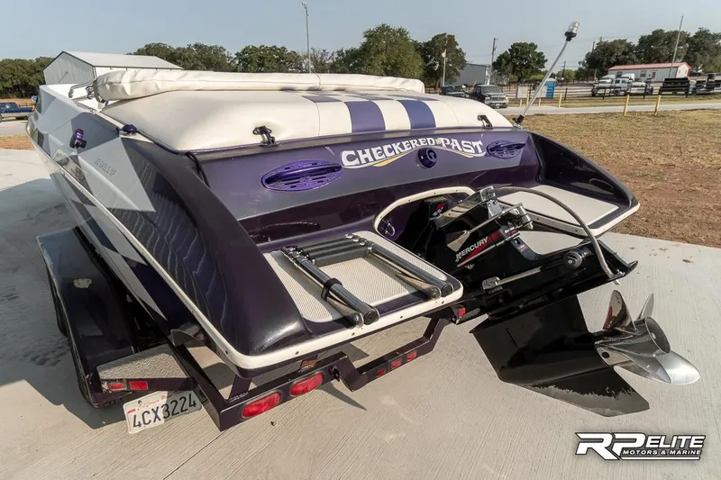 Slide: The Image of 2000 Eliminator 220 Eagle XP boat with trailer, rear view, outdoor setting. - 6