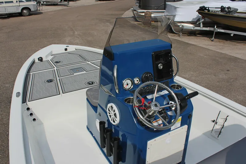 Slide: The Image of 2025 Avid 19 FSX boat with blue console and steering wheel, docked outdoors. - 17