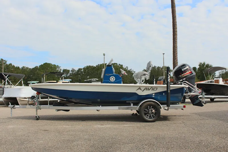 Slide: The Image of 2025 Avid 19 FSX boat on trailer, parked outdoors, side view. - 2