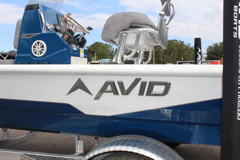 Slide: The Image of Avid 19 FSX 2025 boat with blue and white design on trailer. - 39